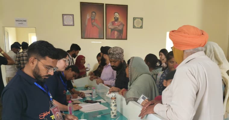 Community members registering patients at the ARK reception desk during a health camp